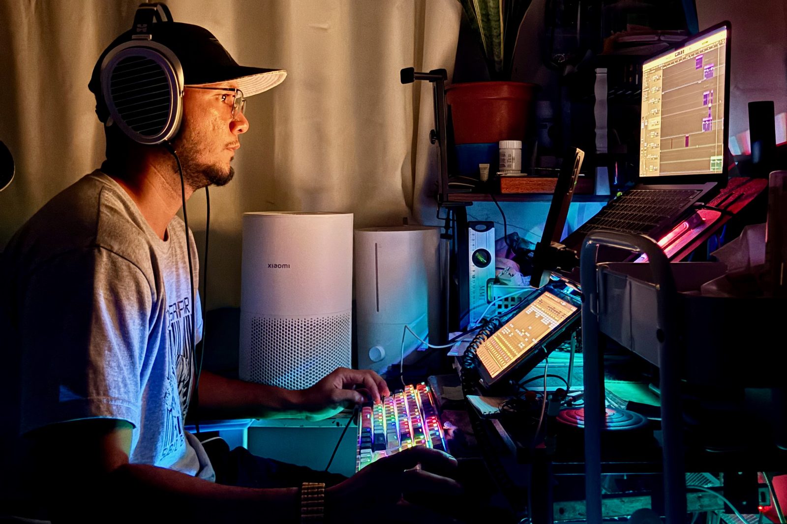 Gelvs at the G Wave Records desk in low light, headphones on, a session open on screen